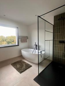 ein Bad mit einer großen Badewanne und einem Fenster in der Unterkunft Escale Doullennaise - Appartement neuf avec terrasse in Doullens