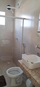 a bathroom with a white toilet and a sink at Casa de Praia Nova, 3 quartos, 1 Suíte, com quintal privativo, em condomínio, muito bem Localizado in Porto Seguro +20 photos