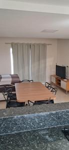 a room with a wooden table and chairs in it at Casa de Praia Nova, 3 quartos, 1 Suíte, com quintal privativo, em condomínio, muito bem Localizado in Porto Seguro