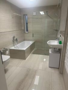 a bathroom with a tub and a toilet and a sink at Quiet 2-Bedroom Apartment - Ideal for Families & Work Stays in Munich +30 photos