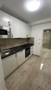 a kitchen with white cabinets and a stove top oven at Schönes Apartment mit eigener Küche und eigenem Bad in Munich