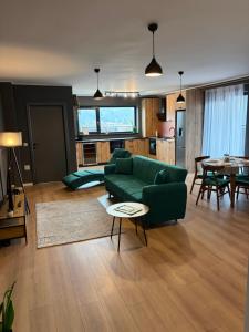 a living room with a green couch and a table at Best View Terrace in Târgu-Mureş