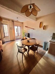 een woonkamer met een tafel en stoelen en een plafondventilator bij Studio L'oasis Ensoleillé in Cuers