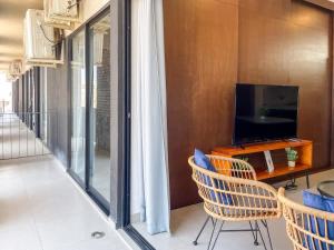 Apartment for 7 people with pool on the 3rd floor في Isla Venados: غرفة معيشة مع تلفزيون وطاولة وكراسي