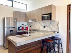 Apartment for 7 people with pool on the 3rd floor في Isla Venados: مطبخ مع حوض ومكتب مع الكراسي