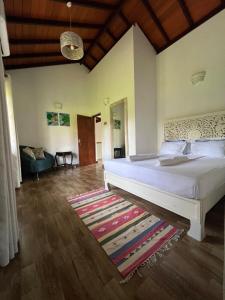a bedroom with a large white bed and a rug at Forest Avenue - Kurunegala in Torayaya