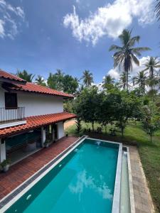 a villa with a swimming pool in front of a house at Forest Avenue - Kurunegala in Torayaya