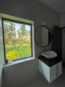 a bathroom with a window with a sink and a mirror at Forest Avenue - Kurunegala in Torayaya +43 photos