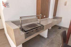 eine Küche mit einer Theke mit einem Grill in der Unterkunft Amplio departamento con alberca in Los Cerritos