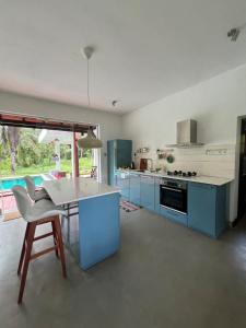 a kitchen with blue cabinets and a table and chairs at Forest Avenue - Kurunegala in Torayaya +41 photos