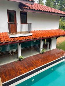 a house with a deck and a swimming pool at Forest Avenue - Kurunegala in Torayaya