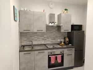 a kitchen with a stove and a sink and a refrigerator at La casa di Flò in Ercolano