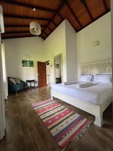a bedroom with a large white bed and a rug at Forest Avenue - Kurunegala in Torayaya
