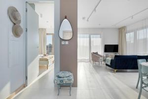 ein Wohnzimmer mit einem blauen Sofa und einem Spiegel in der Unterkunft GREENERI PARK - Ambria Apartments in Świnoujście