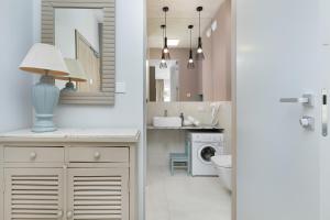 ein Badezimmer mit Waschbecken und Waschmaschine in der Unterkunft GREENERI PARK - Ambria Apartments in Świnoujście + 112 Fotos