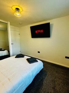 a bedroom with a bed with a sign on the wall at Druridge Apartment in Cowpen +2 photos