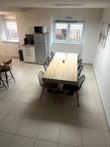 ein Esszimmer mit einem Holztisch und Stühlen in der Unterkunft Gite le Mamama, maison cosy au centre du village in Sommerau + 19 Fotos