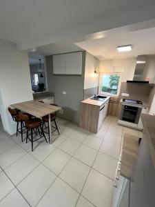 eine große Küche mit Tisch und Stühlen in der Unterkunft Gite le Mamama, maison cosy au centre du village in Sommerau