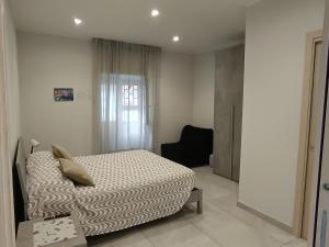 a bedroom with a bed and a chair in it at La casa di Flò in Ercolano