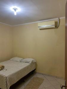 een slaapkamer met een bed en airconditioning aan de muur bij Casa Aconchegante Odc in Olho D’Água do Casado