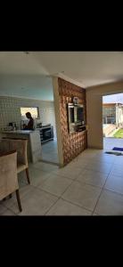 une cuisine avec un comptoir et une personne au loin dans l'établissement Casa Barra do Jacuípe, à Camaçari