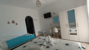 ein weißes Zimmer mit einem Bett und einem Spiegel in der Unterkunft Aelia Studios in Koukounaries