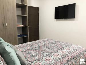 Un dormitorio con una cama y un televisor en una pared. en Apartment with pool 3 blocks from the beach, en Isla Venados 13 fotos más