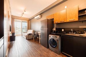 Una cocina con lavadora y secadora en una habitación. en Premium Modern Studio in Alphaville, en Santana de Parnaíba