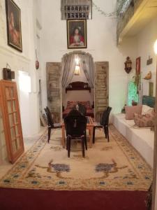un soggiorno con tavolo, sedie e divano di IVANKA Guest House a Fes