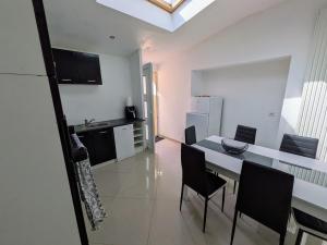 White house between land and sea St Pol de Léon في بلدة سان-بول-دو-ليون: مطبخ وغرفة طعام مع طاولة وكراسي