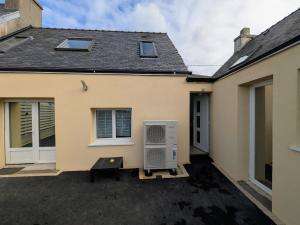 White house between land and sea St Pol de Léon في بلدة سان-بول-دو-ليون: منزل به مكيف هواء في الممر