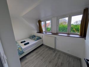 White house between land and sea St Pol de Léon في بلدة سان-بول-دو-ليون: غرفة صغيرة بها سرير ونوافذ