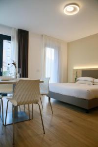 蒂拉诺Bernina Suites - vicino al Bernina Express的一间卧室，里面有一张床、一张桌子和一把椅子