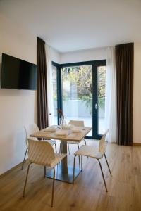 蒂拉诺Bernina Suites - vicino al Bernina Express的餐厅里有一张桌子和几把椅子