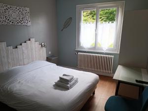 a bedroom with a bed with white sheets and a window at Hôtel-Relais De Trefeuntec in Plonévez-Porzay