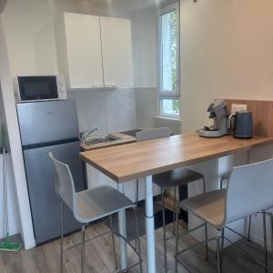 a kitchen with a table and chairs and a refrigerator at Azal france in Vanves