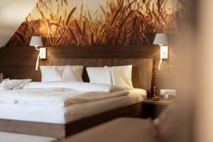 a bedroom with a large bed with white pillows at Die Landhofmühle in Windisch Minihof +31 photos