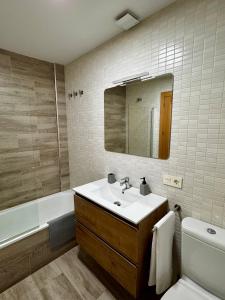 a bathroom with a sink and a toilet and a mirror at Apartamento a 10 minutos de Granada, Sierra Nevada a 35km, parking gratis in Alhendín +21 photos