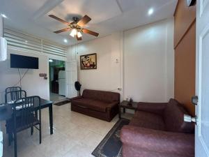 a living room with a couch and a ceiling fan at Queen bed POS walk to everything on the Avenue in Port-of-Spain