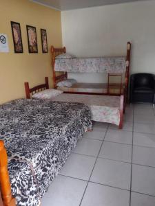 a bedroom with two bunk beds and a tiled floor at Pousada do Nico in São Gabriel