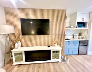 a living room with a television on a wall at Low Tide Suite - Modern, Oceanside Suite with King Bed, Resort Pool & Hot Tub in Nanoose Bay +38 photos