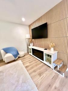 a living room with a flat screen tv on a wall at Low Tide Suite - Modern, Oceanside Suite with King Bed, Resort Pool & Hot Tub in Nanoose Bay