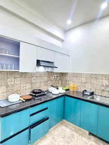 a kitchen with blue cabinets and a sink at The Olivia -Luxury Apartments in Rishīkesh