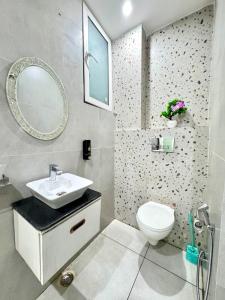 a bathroom with a sink and a toilet and a mirror at The Olivia -Luxury Apartments in Rishīkesh +10 photos