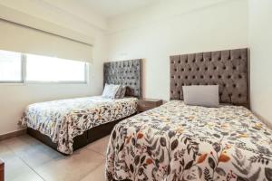 ein Schlafzimmer mit zwei Betten und einem Fenster in der Unterkunft Apartment for 6 on the first floor with pool in Los Cerritos