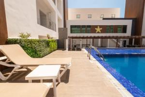 einen Hotelpool mit Stühlen und einem Pool in der Unterkunft Apartment for 6 on the first floor with pool in Los Cerritos