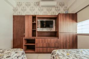 ein Schlafzimmer mit einem TV in einem Holzschrank in der Unterkunft Apartment for 6 on the first floor with pool in Los Cerritos + 19 Fotos