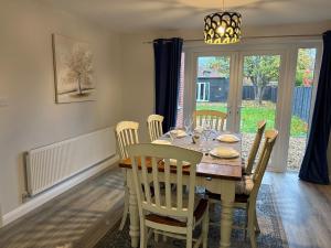 a dining room with a table and chairs and a window at Large 4 bedroom Family let, Contractor, Corporate in Market Harborough