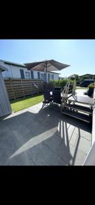 a patio with two chairs and an umbrella at Chalet Home Texel in De Koog