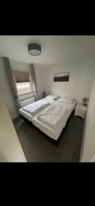 a large bed in a bedroom with a window at Chalet Home Texel in De Koog